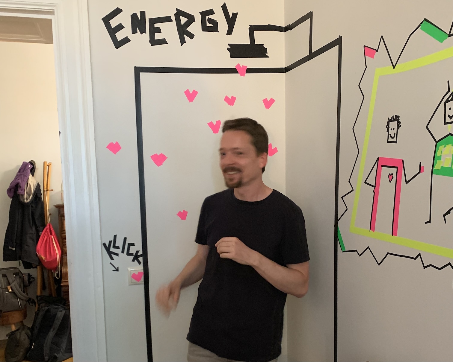 Claus standing in front of a picture of an energy shower made from tape art